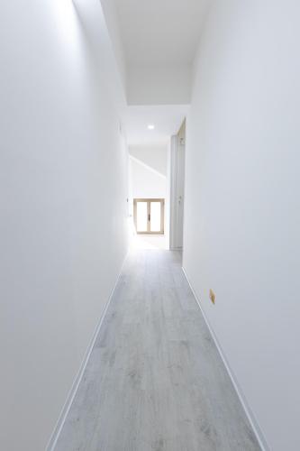 an empty corridor in a white room with a window at Valmontone Travel Rooms in Valmontone