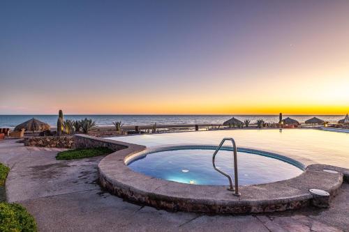 a hot tub with the ocean in the background at Encanto Living Two Bedroom Unit by Kivoya in Puerto Peñasco
