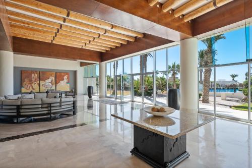 a living room with large windows and a table at Encanto Living Two Bedroom Unit by Kivoya in Puerto Peñasco