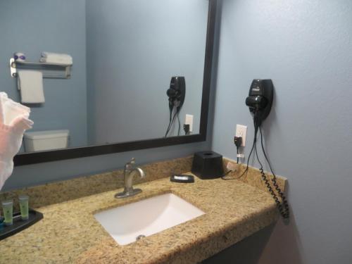 La salle de bains est pourvue d'un lavabo et d'un miroir. dans l'établissement Black Gold Inn, à Yoakum