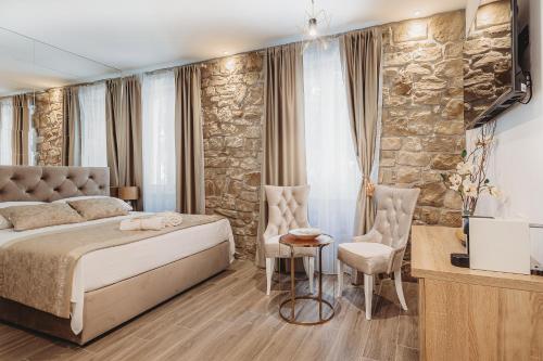 ein Schlafzimmer mit einem Bett und einer Steinmauer in der Unterkunft Four Elements in Split