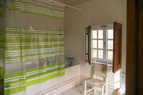 Un baño con una cortina de ducha verde y blanca. en Quinta de Pindela - Natureza e Tradicao, en Vila Nova de Famalicão