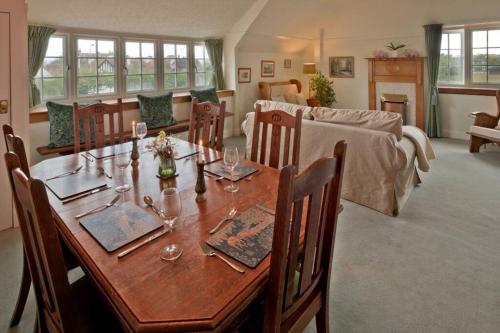 a dining room with a wooden table with wine glasses at Troon Arts & Crafts Period Home Golf Beach in Troon