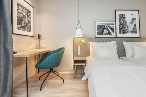 a bedroom with two beds and a desk and a chair at Radisson Hotel Kaunas in Kaunas
