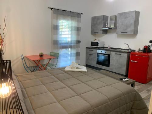 a bedroom with a bed and a kitchen with a table at Villa Anna GuestHouse in Brindisi
