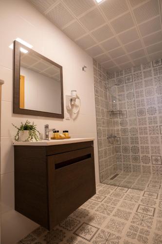 a bathroom with a sink and a shower with a mirror at Urla 1867 Hotel in Urla