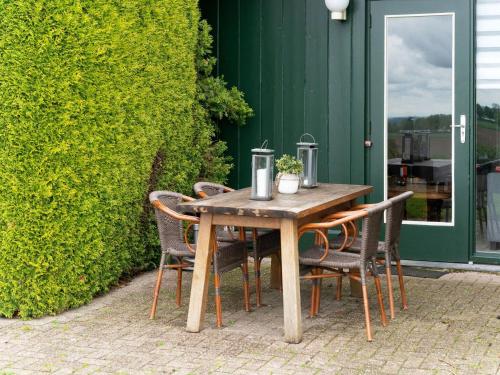 a wooden table and chairs on a patio at Apartment in Ubachsberg near Scenic Trails in Voerendaal