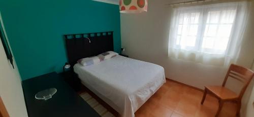 a bedroom with a white bed and a window at Holiday House Tocha in Palheiros da Tocha