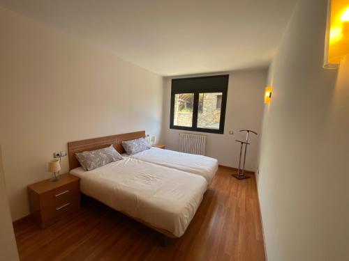 ein kleines Schlafzimmer mit einem Bett und einem Fenster in der Unterkunft Residencial Sol i Ski 24 4p Ransol El Tarter Zona Grandvalira in Sant Pere