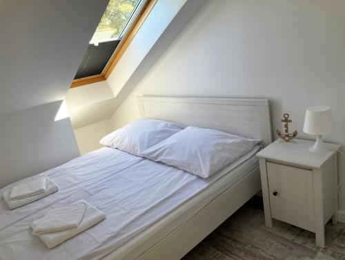 a bedroom with a white bed with a window at Blue Mare BB in Łukęcin