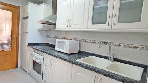 a kitchen with a sink and a microwave at SALINAS GANDIA - Solo alquiler Familias in Gandía