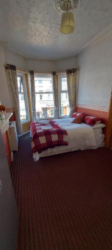a bedroom with a large bed with red pillows at the belvere in Blackpool