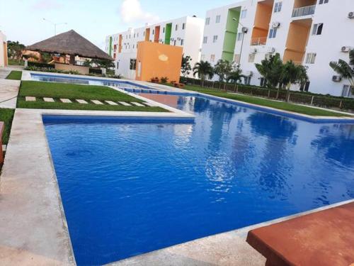 a large blue swimming pool in front of a building at Departamento 3 habitaciones in Cancún