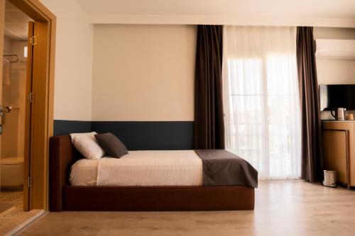 a bedroom with a bed and a window at Urla 1867 Hotel in Urla