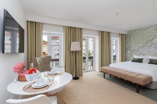 ein Hotelzimmer mit einem Bett, einem Tisch und Stühlen in der Unterkunft Casa de Arouca Porto Apartments in Porto