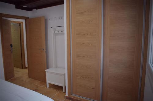 - une chambre avec un placard en bois et un lit dans l'établissement Pincheiro Apartamentos Turísticos, à Pobra do Caramiñal