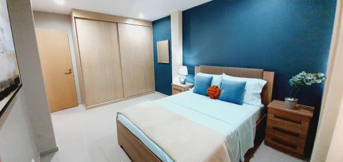 a bedroom with a large bed with a blue wall at kelly's House Plateau City Center in Praia