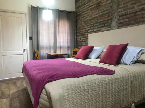 a bedroom with a large bed with purple sheets at Apart Hotel Don Domingo Coñaripe in Coñaripe