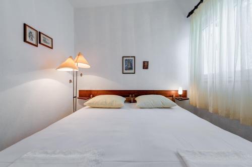 een groot wit bed in een slaapkamer met een raam bij Beachfront Apartment Pisak (196-1) in Pisak