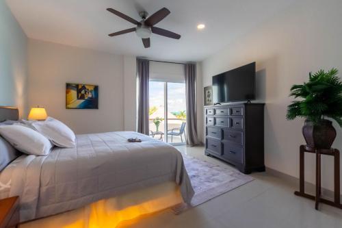 a bedroom with a bed and a flat screen tv at Sunset Condo 104 Puerta al Mar Isla Mujeres Mexico in Isla Mujeres