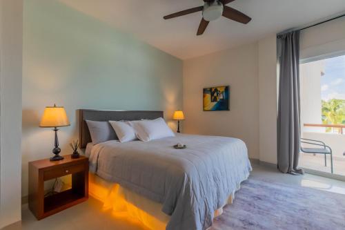 a bedroom with a bed and a large window at Sunset Condo 104 Puerta al Mar Isla Mujeres Mexico in Isla Mujeres