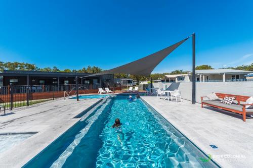 a person is swimming in a swimming pool at BIG4 Colonial Holiday Park Harrington in Harrington