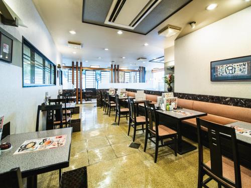 a dining room with tables and chairs in a restaurant at Nagasaki Bus Terminal Hotel in Nagasaki