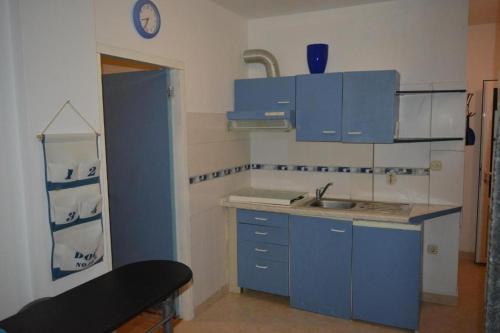 uma cozinha com armários azuis e um lavatório em Apartment in Vrsi with Balcony, Air conditioning, Wi-Fi (4824-4) em Vrsi