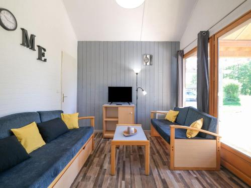 a living room with a blue couch and a table at Comfortable holiday home with private terrace in Signy-le-Petit