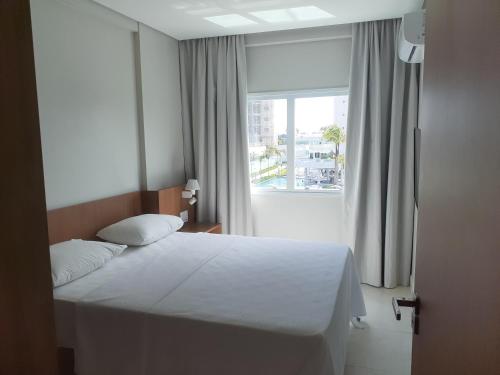 a bedroom with a white bed and a window at Salinas Exclusive Resort in Salinópolis