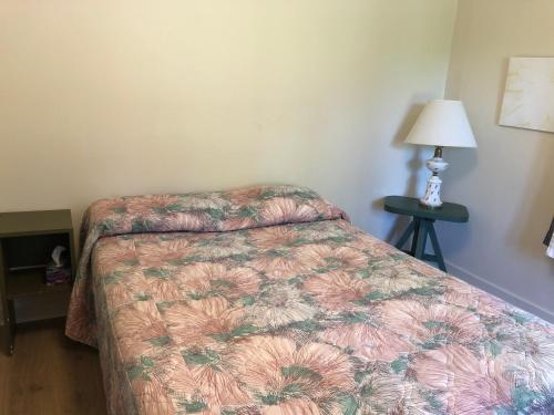 a bedroom with a bed and a lamp on a table at Auberge La Coudriere (Cool Hotel) in L'Isle-aux-Coudres