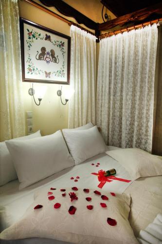 a bed with red rose petals on it at Palazzo di Pietro in Chania Town