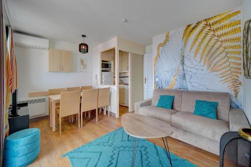 un salon avec un canapé et une table dans l'établissement IMMOGROOM - 2 Rooms sea view - Renovated - Pool - Terrace - Parking - AC, à Cannes