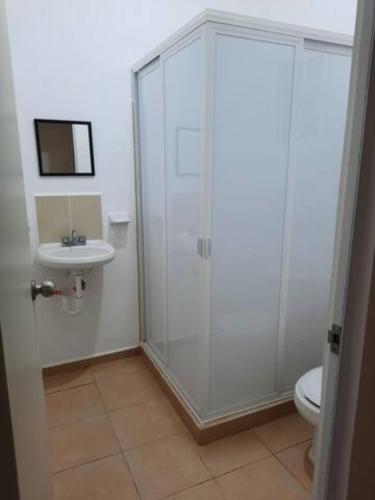 a bathroom with a shower and a toilet and a sink at Departamento 3 habitaciones in Cancún