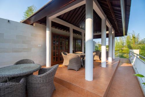 un patio al aire libre con sillas de mimbre y una mesa en Sayang Sanur Terrace House, en Sanur