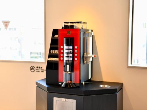 a red coffee machine sitting on top of a table at Wakoshi Tobu Hotel in Wako