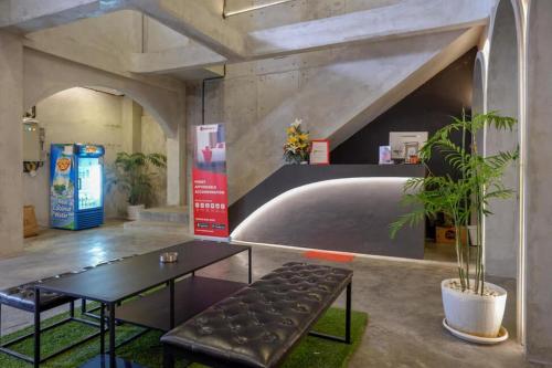a lobby with a table and a bench in a room at RedDoorz Plus near Kawasan Sam Poo Kong Semarang in Semarang
