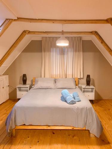 a bedroom with a bed with two blue towels on it at Hotel El Tesoro de Elqui in Pisco Elqui