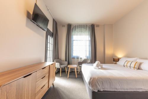 a hotel room with a large bed and a television at Lakemba Hotel in Sydney