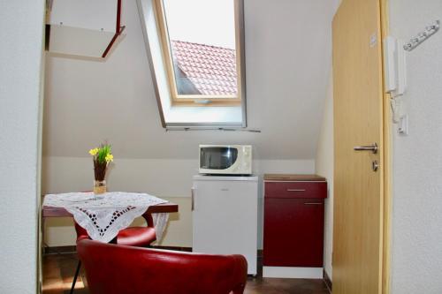 a small kitchen with a table and a microwave at KrabatResidenz - Apartmenthaus in Burg