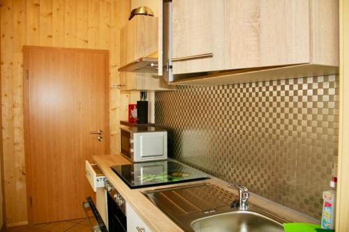 a kitchen with a sink and a microwave at KrabatResidenz - Apartmenthaus in Burg