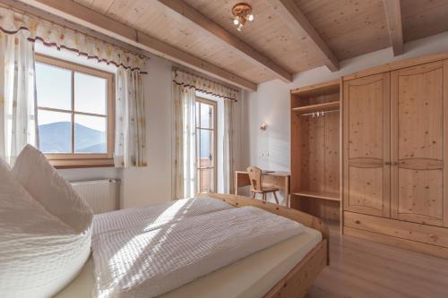 a bedroom with a bed and a desk and a window at Häuslerhof in Valdaora