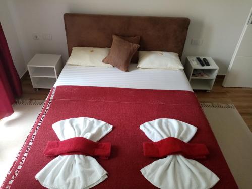 a bed with three red and white towels on it at Apartman TAJNA Vrdnik in Vrdnik
