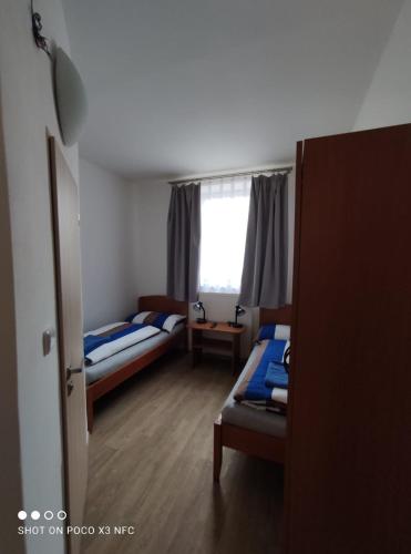 a bedroom with two beds and a window at Penzion DUHET in Hulín