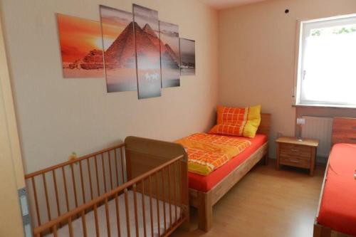 mały pokój z łóżkiem i łóżeczkiem dziecięcym w obiekcie Petriheil w mieście Nohfelden