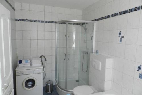 uma casa de banho branca com um chuveiro e um WC. em Petriheil em Nohfelden