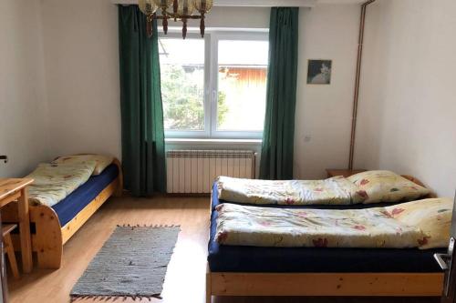 a bedroom with two beds and a window at Dom Janosik in Kacwin