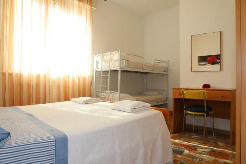 a bedroom with a bed and a desk and a window at Casa Meris in Fano