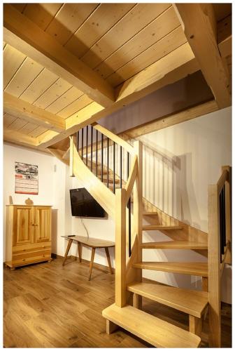 a wooden staircase in a living room with a television at Tatrzańska Kotwica in Witów