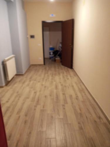 an empty room with a wooden floor and a hallway at San vito 9 in Agrigento